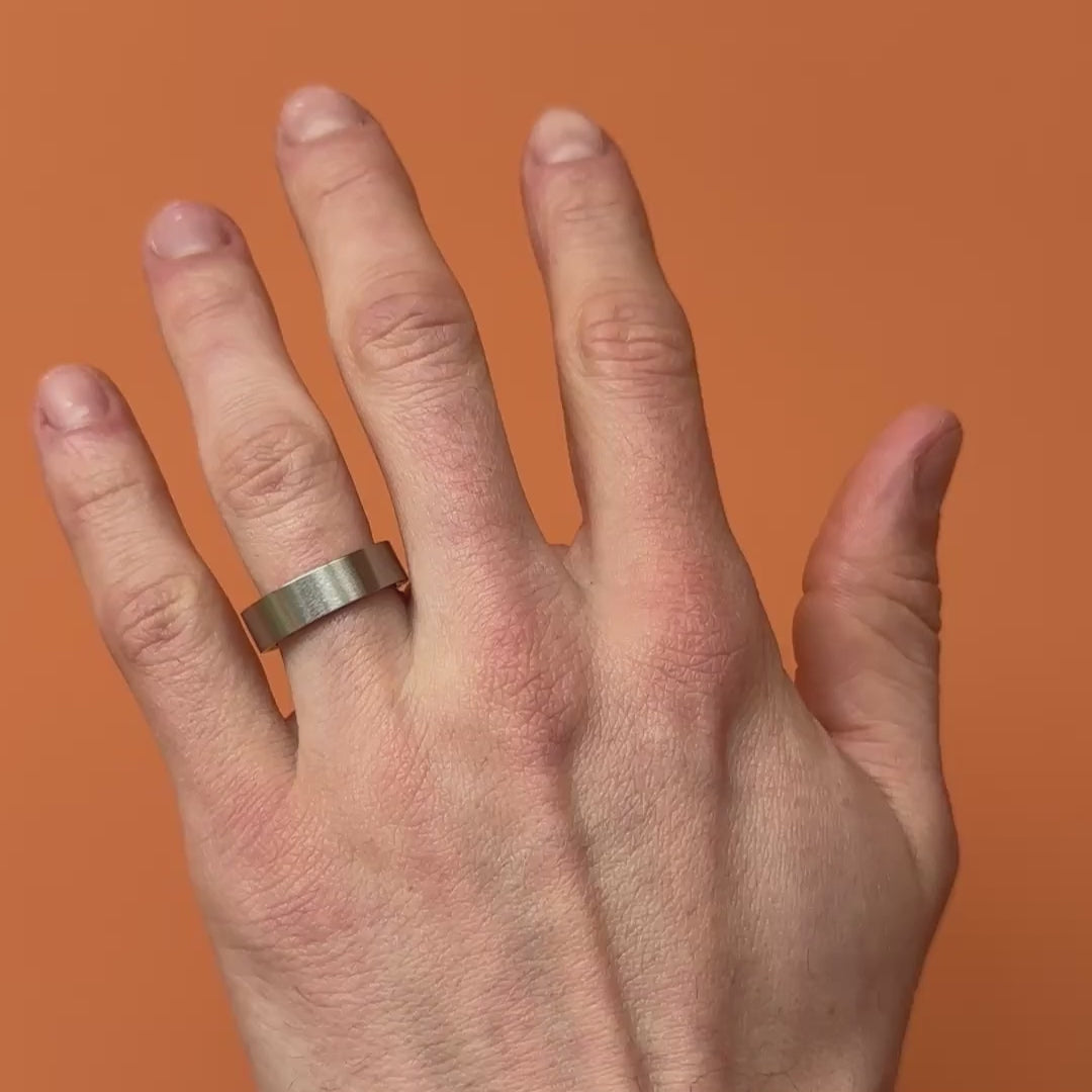 Video of flat brushed titanium ring on a hand. By Bound.